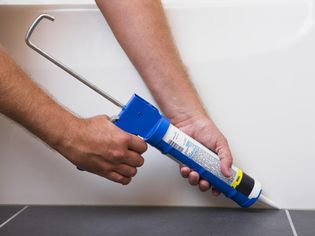 Man using caulking gun, close-up