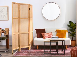 An accordion room divider separating a living room and a dining room