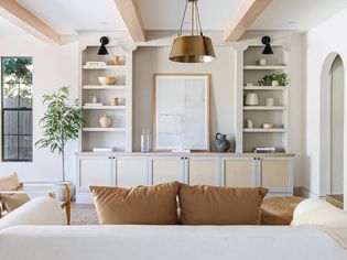 A large living room with white built-in bookshelves.