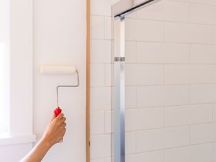 White paint added to bathroom wall with paint roller