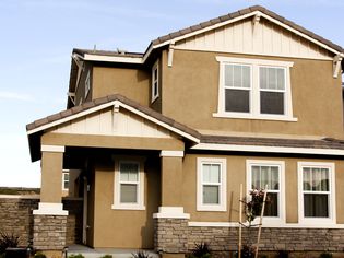 Brown stucco home with white trim