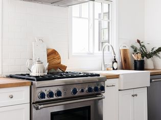 Modern kitchen with white tiled wall and butcher block countertop