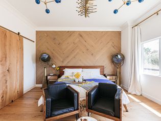 Bedroom with contemporary lighting and leather chairs