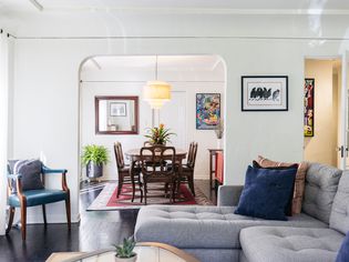 Mid-century modern designed living room with tufted couch in front of dining room