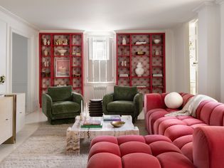 Pink tufted couch with green accent chairs in living room