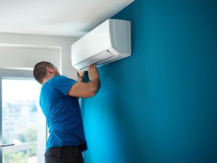 Person installing a new air conditioner in a home