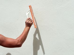 Person repairing stucco