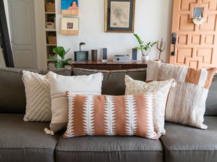 Gray couch covered with patterned throw pillows near front entrance