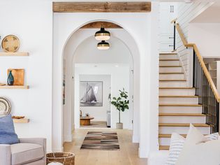 Decorated hallway with white arched walls next to staircase