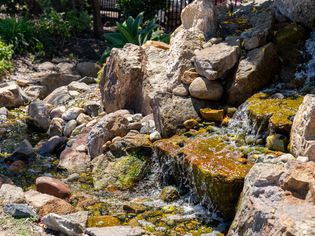 Outdoor waterfall with large rocks and water cascading down to stream