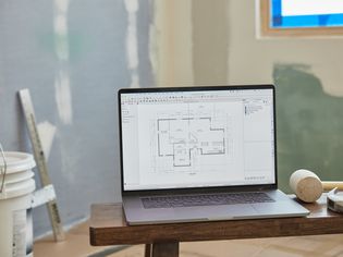 House floor-plan on computer in middle of room being renovated