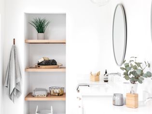 Remodeled bathroom with brightly lit white walls with natural decor in neutral colors