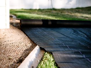 rolling out landscaping fabric