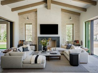 neutral living room with wooden ceiling beams and white linen couches