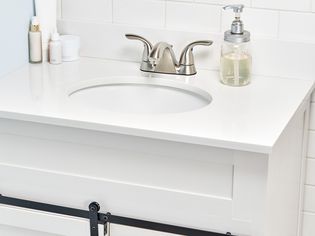 Newly installed bathroom vanity with white countertop and single sink