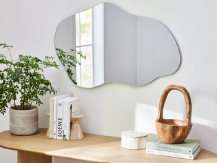 Frameless mirror hanging over console table